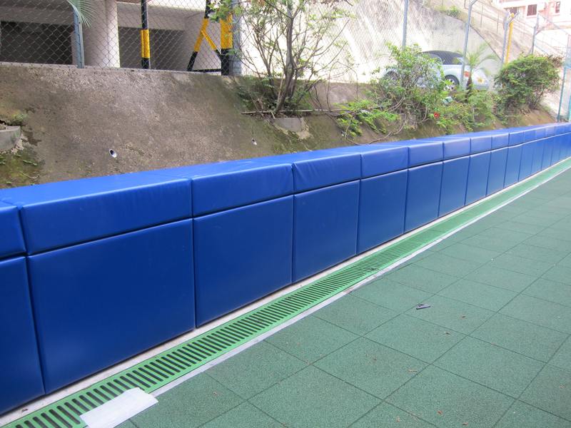 Blue impact wall padding beside an outdoor activity area